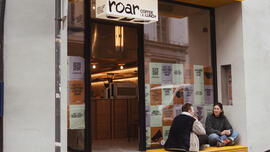 Twee jongeren zitten voor de nieuwe koffiebar Roar in Gent